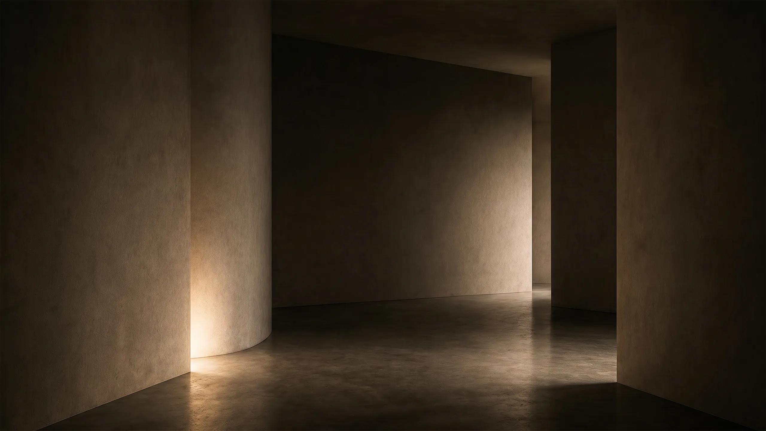 Minimal interior of curved walls and deep shadow, with indirect warm light revealing proportion and depth.